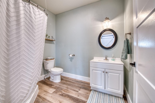 full bath featuring wood finished floors, toilet, vanity, baseboards, and curtained shower