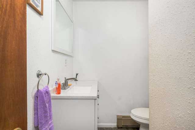 412 Spruce St, Anaconda, MT 59711 - bathroom with a baseboard radiator, vanity, and toilet