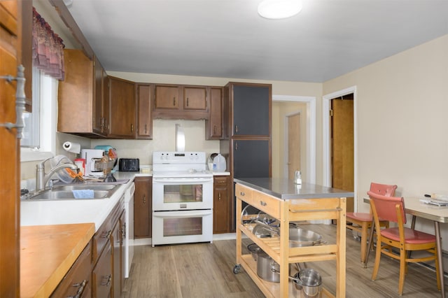 412 Spruce St, Anaconda, MT 59711 - kitchen featuring range with two ovens, a sink, light countertops, light wood-type flooring, and brown cabinetry
