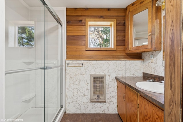 222 Lundeen Rd, Eureka, MT 59917 - full bath with heating unit, a stall shower, wood finished floors, vanity, and wallpapered walls