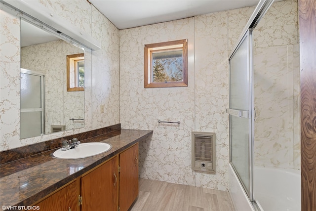 222 Lundeen Rd, Eureka, MT 59917 - bathroom featuring heating unit, wood finished floors, vanity, and enclosed tub / shower combo
