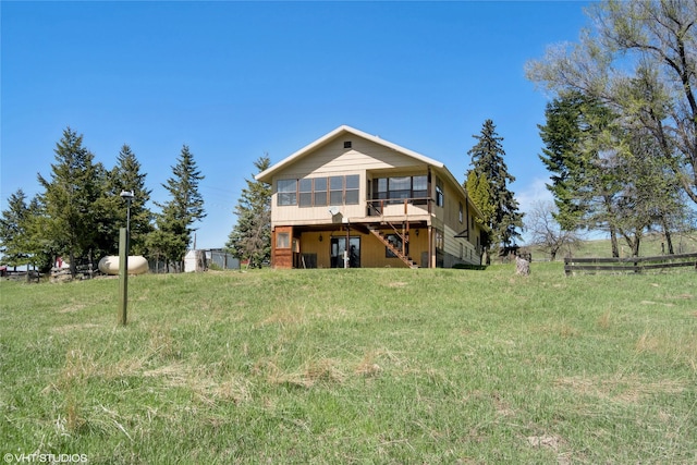222 Lundeen Rd, Eureka, MT 59917 - back of property featuring a sunroom, stairway, and fence