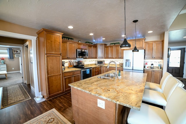 121 Choteau Ave NE, Great Falls, MT 59404 - kitchen featuring appliances with stainless steel finishes, a sink, brown cabinets, dark wood-style floors, and recessed lighting