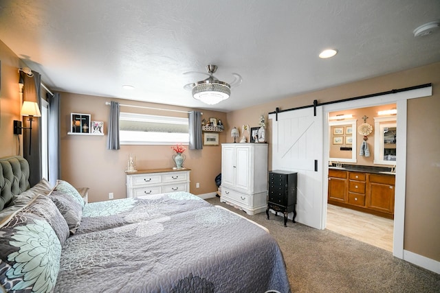 121 Choteau Ave NE, Great Falls, MT 59404 - bedroom with a barn door, light carpet, baseboards, recessed lighting, and connected bathroom
