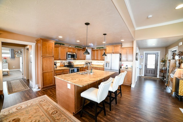 121 Choteau Ave NE, Great Falls, MT 59404 - kitchen with stainless steel appliances, a sink, dark wood-style floors, baseboards, and a center island with sink