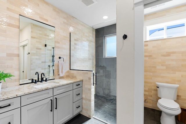 5519 Golf Dr, Lolo, MT 59847 - bathroom featuring tile walls, a stall shower, vanity, tile patterned flooring, and toilet