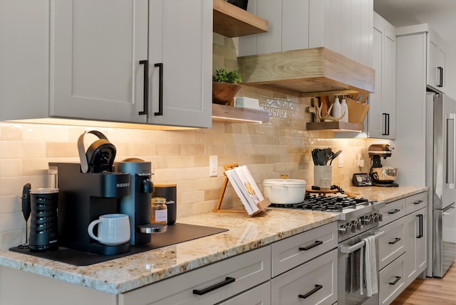 5519 Golf Dr, Lolo, MT 59847 - kitchen featuring open shelves, stainless steel stove, tasteful backsplash, light stone countertops, and island exhaust hood