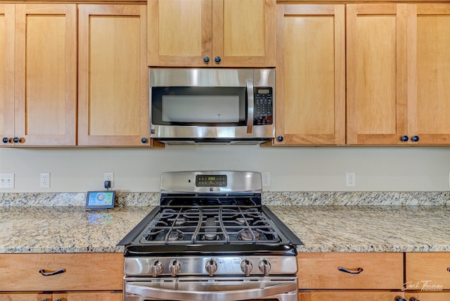 7175 Bootlegger Dr, Helena, MT 59602 - kitchen featuring appliances with stainless steel finishes, light brown cabinets, and light stone countertops