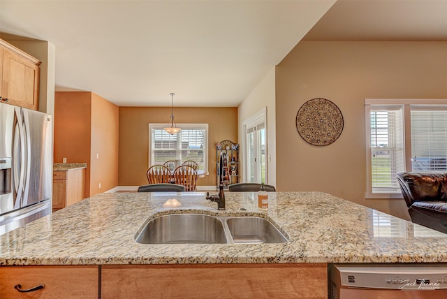 7175 Bootlegger Dr, Helena, MT 59602 - kitchen with stainless steel fridge, a sink, dishwashing machine, light stone countertops, and hanging light fixtures