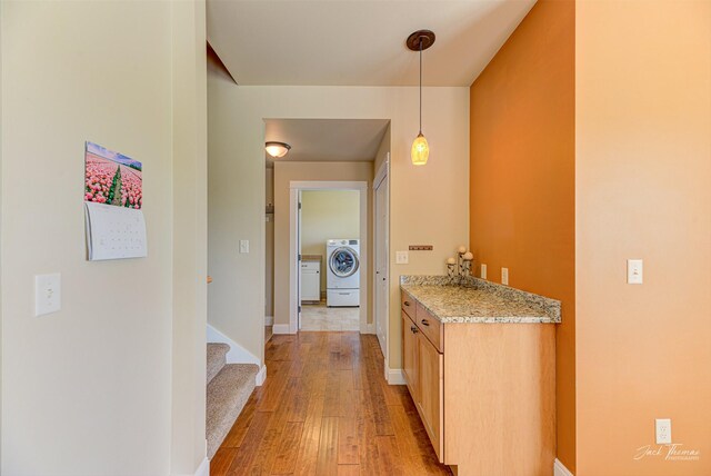 7175 Bootlegger Dr, Helena, MT 59602 - hall with washer / dryer, light wood-style floors, baseboards, and stairs