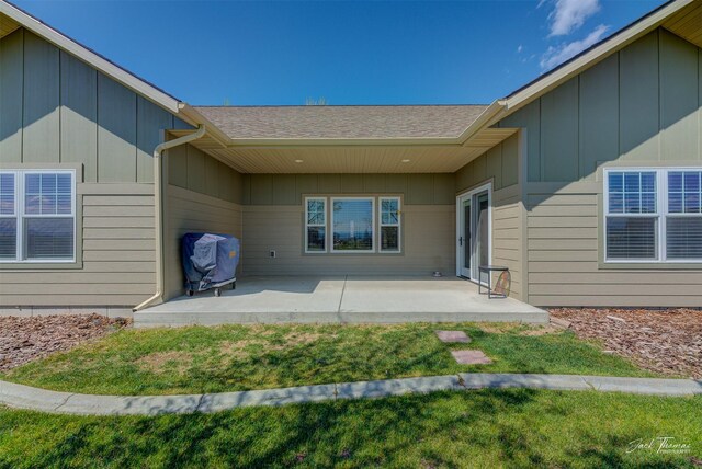 7175 Bootlegger Dr, Helena, MT 59602 - rear view of house with a patio area, roof with shingles, and a yard
