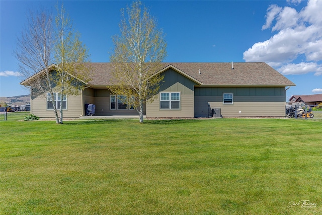 7175 Bootlegger Dr, Helena, MT 59602 - back of house featuring board and batten siding, a yard, and roof with shingles