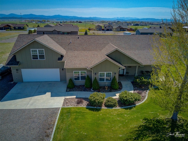 7175 Bootlegger Dr, Helena, MT 59602 - view of front of home featuring concrete driveway, a shingled roof, a mountain view, board and batten siding, and a front yard