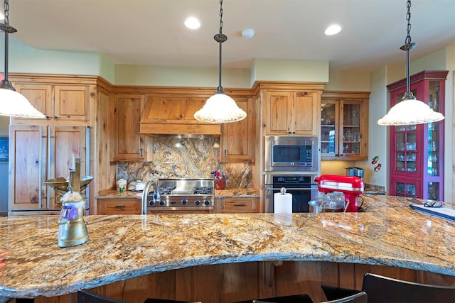 470 Salmon Way, Corvallis, MT 59828 - kitchen with appliances with stainless steel finishes, custom exhaust hood, glass insert cabinets, light stone counters, and tasteful backsplash