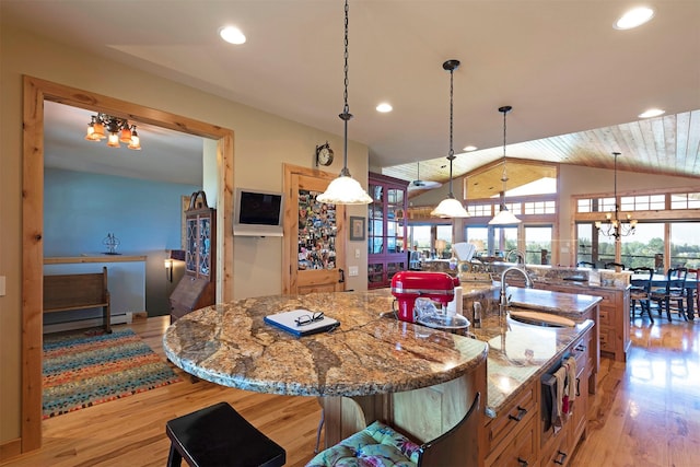 470 Salmon Way, Corvallis, MT 59828 - kitchen featuring a sink, light wood-style flooring, a large island, vaulted ceiling, and light stone countertops