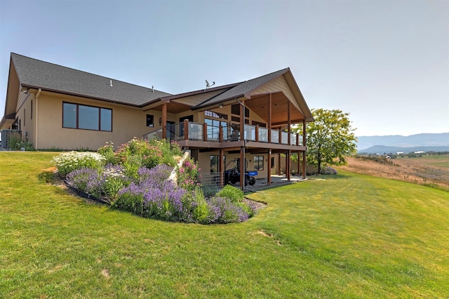 470 Salmon Way, Corvallis, MT 59828 - back of property featuring a yard, a patio area, a deck with mountain view, and stucco siding