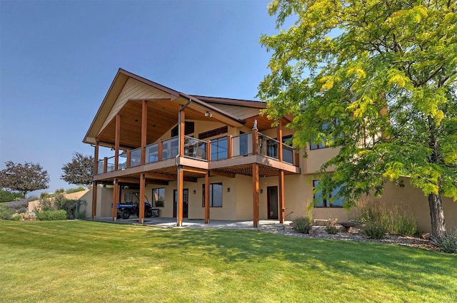 470 Salmon Way, Corvallis, MT 59828 - back of house with a yard, stucco siding, a patio, and a balcony