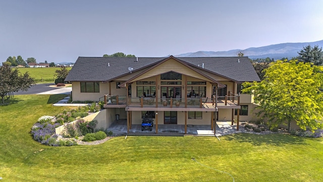 470 Salmon Way, Corvallis, MT 59828 - back of property featuring a patio area, a lawn, a deck with mountain view, and stucco siding
