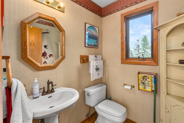 bathroom featuring a sink, toilet, and baseboards