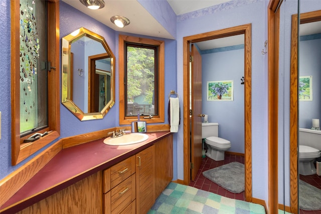 bathroom with toilet, vanity, and baseboards