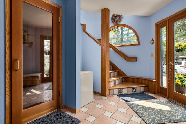 foyer entrance featuring healthy amount of natural light, stairway, and baseboards