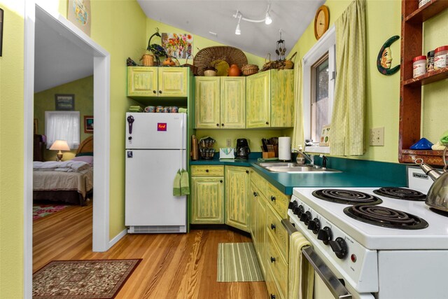 kitchen with white appliances, a sink, lofted ceiling, light wood-style floors, and green cabinetry