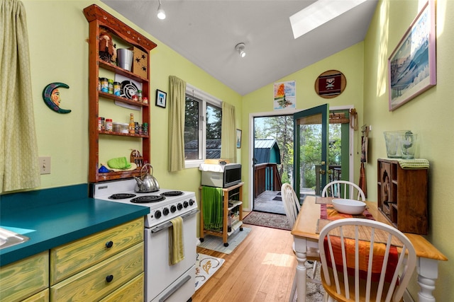 kitchen with white electric range oven, light wood finished floors, open shelves, green cabinetry, and vaulted ceiling