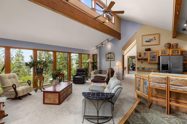 living room featuring track lighting, ceiling fan, and light colored carpet