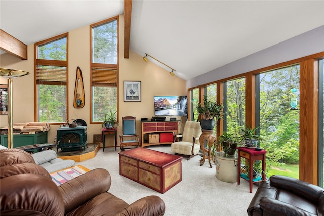 carpeted living room with a wood stove, beamed ceiling, and high vaulted ceiling