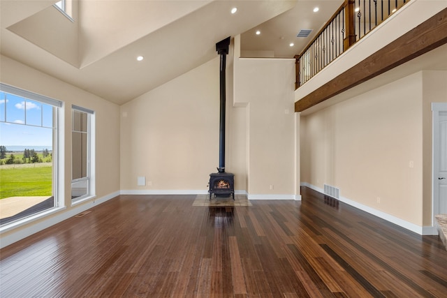 125 Schlegel View Rd, Kalispell, MT 59901 - unfurnished living room featuring high vaulted ceiling, a wood stove, wood finished floors, recessed lighting, and baseboards