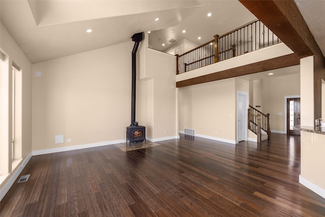 125 Schlegel View Rd, Kalispell, MT 59901 - unfurnished living room featuring stairway, high vaulted ceiling, a wood stove, wood finished floors, and recessed lighting