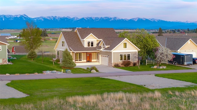 125 Schlegel View Rd, Kalispell, MT 59901 - view of front facade with a mountain view, concrete driveway, a front yard, and stone siding