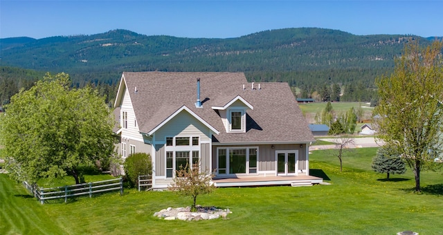 125 Schlegel View Rd, Kalispell, MT 59901 - back of house with a deck with mountain view, board and batten siding, a shingled roof, and a view of trees