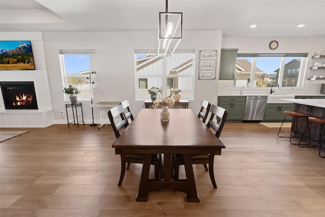 131 Owl Loop, Kalispell, MT 59901 - dining space featuring light wood finished floors, a large fireplace, and recessed lighting