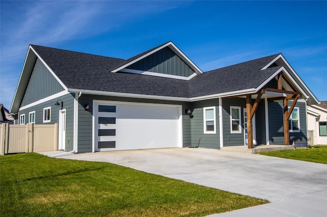 131 Owl Loop, Kalispell, MT 59901 - view of front of home with board and batten siding, driveway, a garage, a shingled roof, and a porch