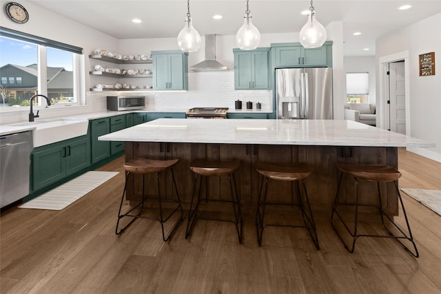 131 Owl Loop, Kalispell, MT 59901 - kitchen with wall chimney exhaust hood, stainless steel appliances, dark wood-style flooring, tasteful backsplash, and a kitchen island