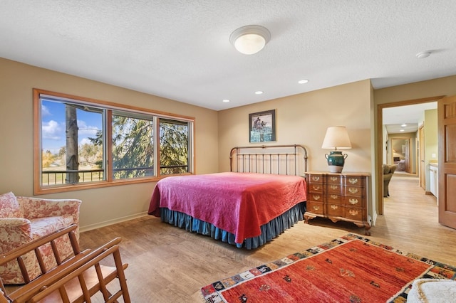 240 Eagle Bend Dr, Bigfork, MT 59911 - bedroom featuring wood finished floors, a textured ceiling, and recessed lighting