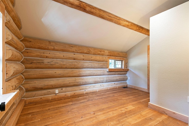 bonus room with vaulted ceiling, rustic walls, baseboards, and light wood-style floors