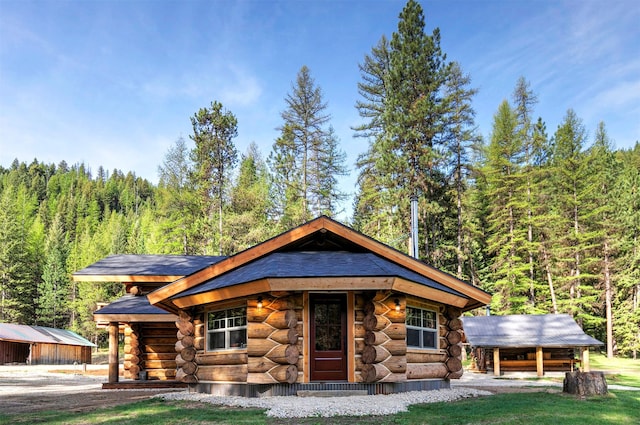 4991 Petty Creek Rd, Alberton, MT 59820 - cabin featuring log siding, a forest view, and an outbuilding