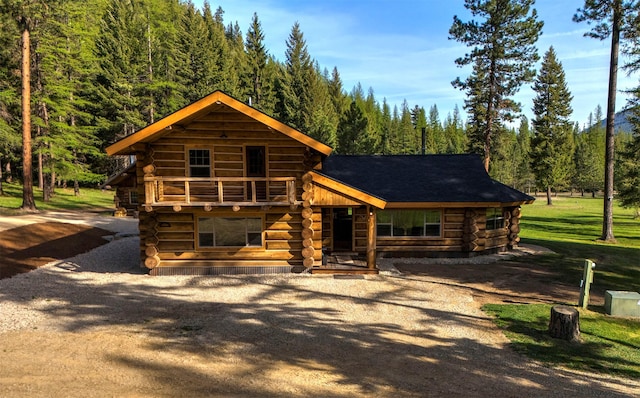 cabin featuring log exterior and a wooded view