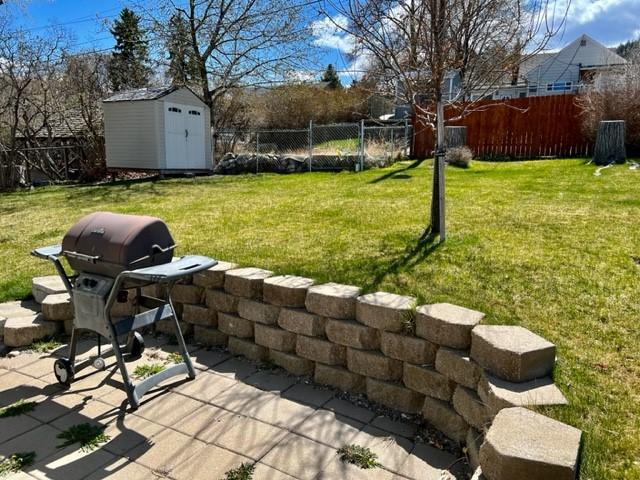 915 Hauser Blvd, Helena, MT 59601 - view of yard featuring a storage shed, an outbuilding, and a patio area