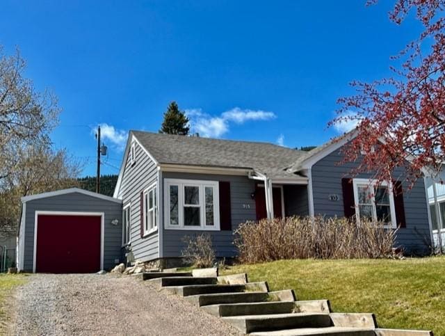 915 Hauser Blvd, Helena, MT 59601 - view of front of house featuring an outbuilding, a garage, dirt driveway, and a front lawn