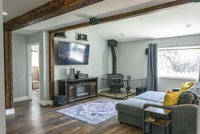 179 Fairmont Rd, Kalispell, MT 59901 - living room with a wood stove, beam ceiling, dark wood finished floors, and baseboards