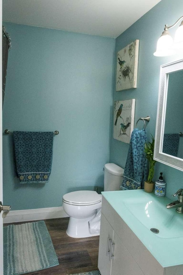 179 Fairmont Rd, Kalispell, MT 59901 - bathroom with wood finished floors, toilet, vanity, and baseboards