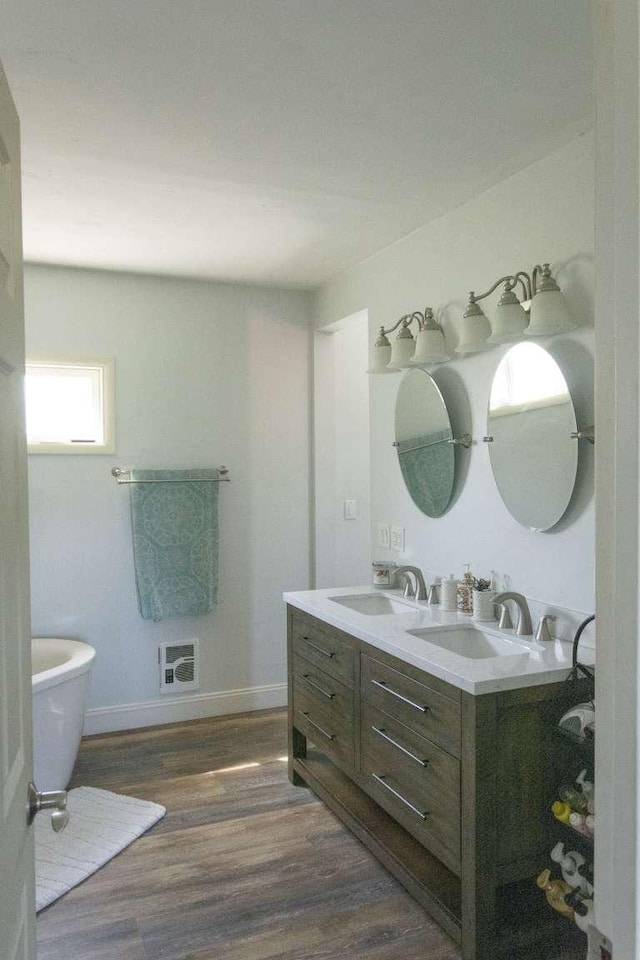 179 Fairmont Rd, Kalispell, MT 59901 - full bath with wood finished floors, double vanity, a freestanding bath, and baseboards
