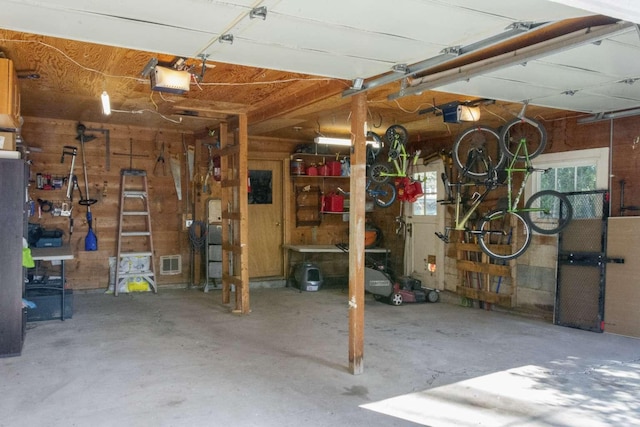 179 Fairmont Rd, Kalispell, MT 59901 - garage featuring a garage door opener, wooden walls, and a workshop area