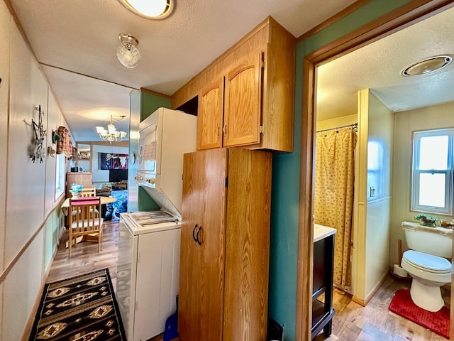 3000 Villard Ave Unit 80, Helena, MT 59601 - interior space featuring light wood-style floors, a textured ceiling, a chandelier, and estacked washer and dryer