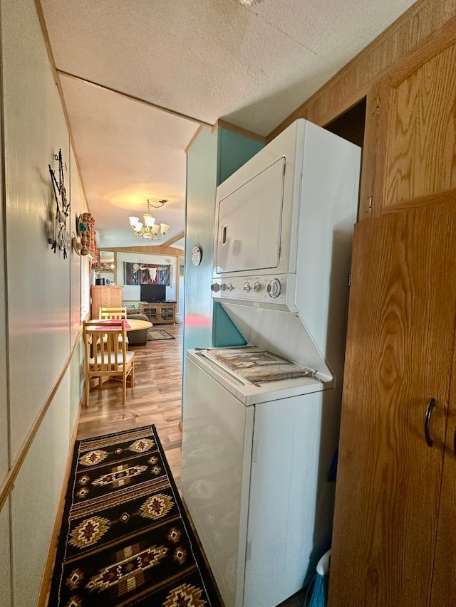 3000 Villard Ave Unit 80, Helena, MT 59601 - laundry area with stacked washing machine and dryer, a chandelier, and wood finished floors