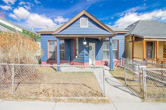 717 W Quartz St, Butte, MT 59701 - shotgun-style home featuring a porch, a gate, a fenced front yard, and a shingled roof