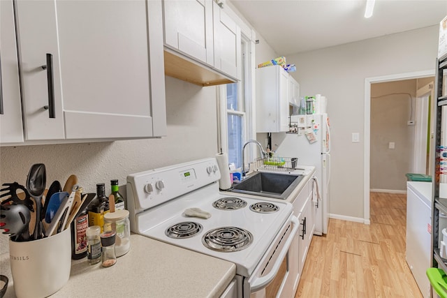717 W Quartz St, Butte, MT 59701 - kitchen with white electric range oven, a sink, light wood-type flooring, light countertops, and white cabinetry